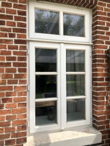 Holzfenster mit Sprossen und Oberlicht.