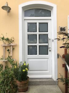 Haustür in weiß mit Glaseinsatz und Sprossen.